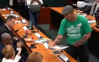 Homem com camisa do Hamas distribui panfletos durante sessão convocada por deputados do PT na Câmara